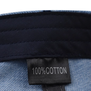 Detailed macro shot of the 100% cotton material label on blue denim beret