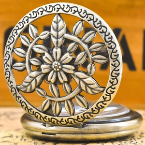 Close-up of vintage bronze pocket watch featuring hollow carved floral lid design
