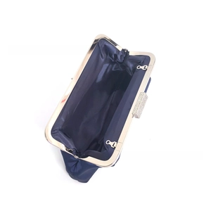 Detailed interior of a navy satin evening clutch with sparkling rhinestone clasp and gold frame