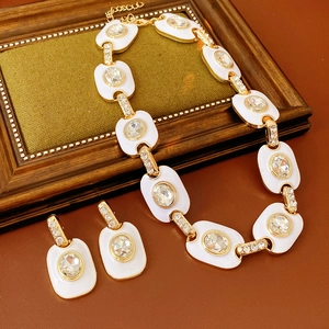 Vue détaillée d'un ensemble collier et boucles d'oreilles vintage en or et émail