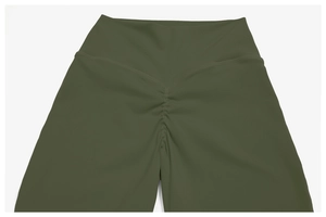 Vue macro détaillée de la couture froncée à la taille haute du pantalon de yoga vert