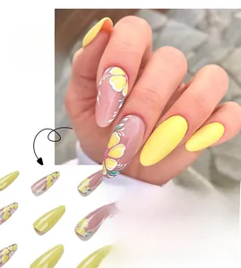 Detail of long oval press-on nails featuring yellow flower art and leaf patterns