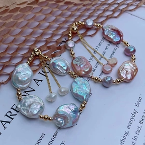 Dettaglio di braccialetti con perle barocche e perline d'oro su sfondo di pagina di libro