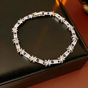 Bracciale in argento con pietre blu e maglie a X con zirconi su pelle nera