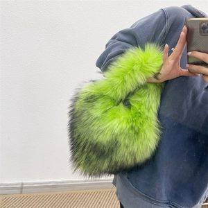 Detail of neon green faux fur plush handbag with black tips in a casual mirror selfie view