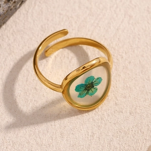 Close-up of 18K gold plated ring featuring a real green dried flower in acrylic resin
