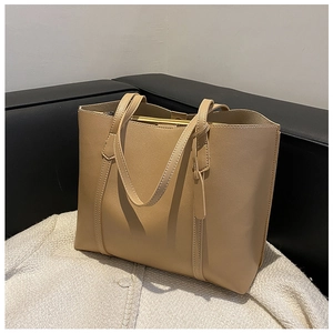 Detail of khaki large capacity soft leather tote bag with fine stitching on white fabric