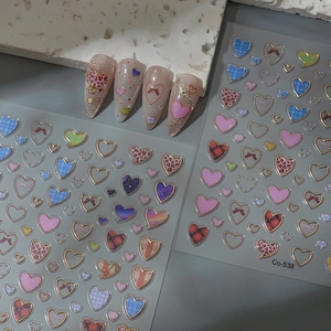 Detail of pink leopard heart nail stickers with gold outlines and plaid patterns