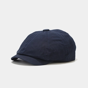 Detailed close-up of navy blue cotton canvas newsboy cap with premium stitching texture