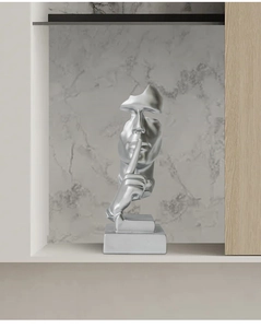 Detail of a matte silver abstract sculpture showing the silent gesture for modern home decor