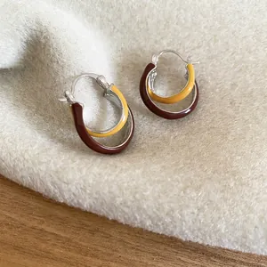 Vintage caramel and yellow enamel crossover hoop earrings on soft plush background