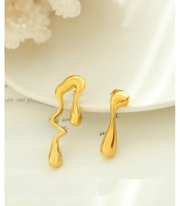 Detalle de pendientes asimétricos bañados en oro 18K con textura de metal líquido