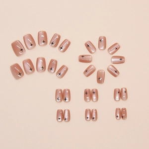 Detailed view of 24 rose gold cat-eye press-on nails with black star patterns