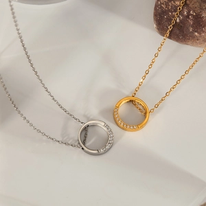 Detail of gold and silver ring necklaces with pave zircon accents on a textured tray