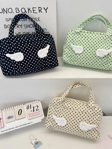 Polka dot quilted travel cosmetic bags with 3D wings shown in green, black, and beige