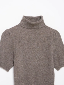 Close-up of dark brown knit dress showing soft cashmere texture and turtleneck detail