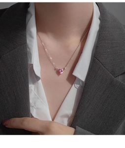 Close-up of pink heart-shaped crystal pendant on a delicate silver necklace for women