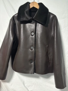 Detail of dark brown faux leather jacket with plush black faux fur collar and button closure