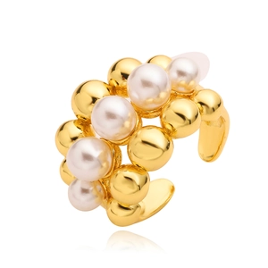 Detailed view of layered C-shaped ring featuring polished gold beads and white pearls