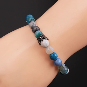 Close-up of 8mm faceted stone beads bracelet with a black crown charm on a model hand