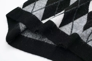 Close-up of diamond pattern knit fabric and ribbed edge on women's knit dress