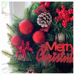 Detailansicht der Weihnachtskranz-Details mit roten Beeren, Tannenzapfen und Dekokugeln