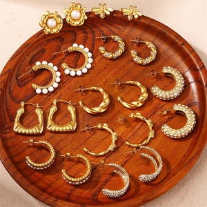 Retro-Ohrring-Set mit Perlensteckern und Strass-Creolen auf einem Holztablett