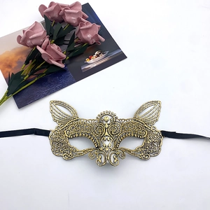 Detailed close-up of golden lace masquerade mask with elegant black satin ribbons