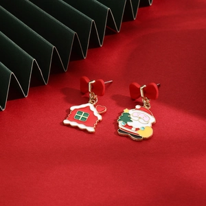 Detail of Christmas earrings featuring Santa Claus and house pendants on red bows