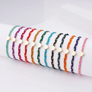Set of 12 colorful braided heart charm bracelets on minimalist white display