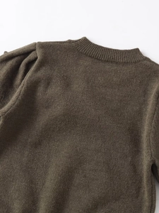 Détail du haut en maille olive montrant le col côtelé et l'épaule à manches bouffantes