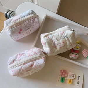 Vue détaillée de trousses à maquillage en coton matelassé fleuri avec nœud