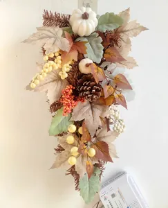 Detailed view of autumn wreath with white pumpkins, pine cones, and colorful maple leaves