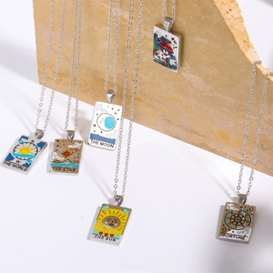 Detail of tarot card necklaces with colorful enamel pendants on natural stone props