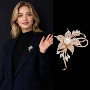 Elegante spilla a fiore dorata con perle e strass mostrata su modella e sfondo scuro