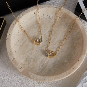 Detailed shot of interlocking heart and ring pendants on stylish paperclip chains