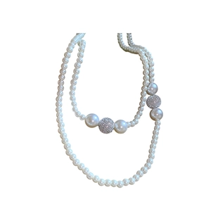 Double-layered pearl necklace with rhinestone-studded balls and polished metal accents