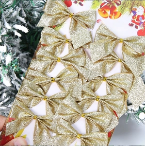 Detailed view of 12pcs gold glitter Christmas bows on a card for tree decoration