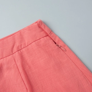 Detail of coral pink cotton skirt with invisible side zipper and linen texture