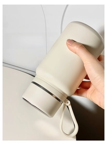 Leak-proof test showing an inverted cream stainless steel vacuum insulated bottle