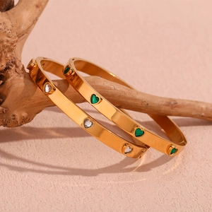 Macro shot of 18K gold plated heart zircon bracelets on rustic wood background