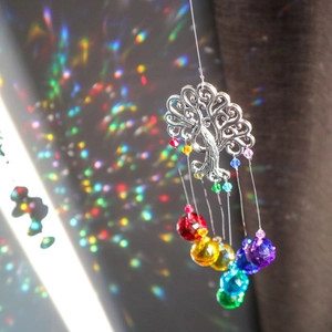 Detail of tree of life suncatcher with crystal beads casting rainbow light on wall