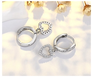 Detailed view of S925 silver hoop earrings with pave-set shimmering heart charms