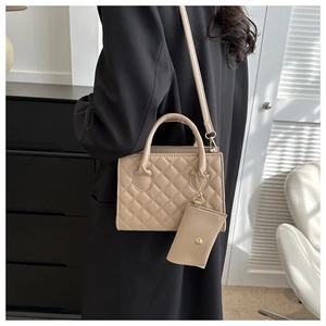 Detail of beige quilted PU leather handbag with matching coin purse and golden hardware
