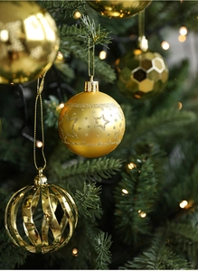 Detail of assorted gold Christmas balls with star and honeycomb patterns on tree