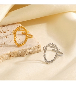 Vista dettagliata di anelli a sfere in oro e argento su elegante raso beige