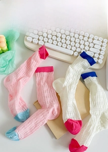 Détail de deux paires de chaussettes en tricot ajouré avec maille et bouts colorés