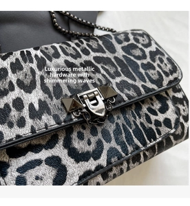 Nahaufnahme der Leoparden-Handtasche mit Metallglanz und Nieten-Drehverschluss-Detail