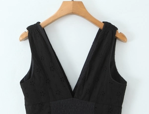 Détail de robe noire à col en V avec broderie florale ajourée et taille élastique
