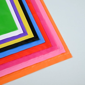 Stack of colorful PE plastic shopping bags with die-cut handles in multiple vibrant colors